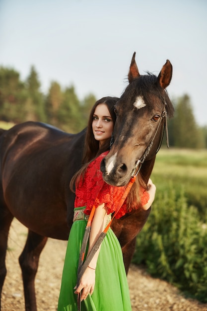 Gitane monte un cheval dans un champ en été.