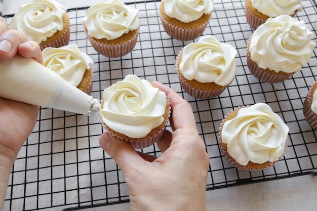 Glaçage à la rose sur des cupcakes à la vanille