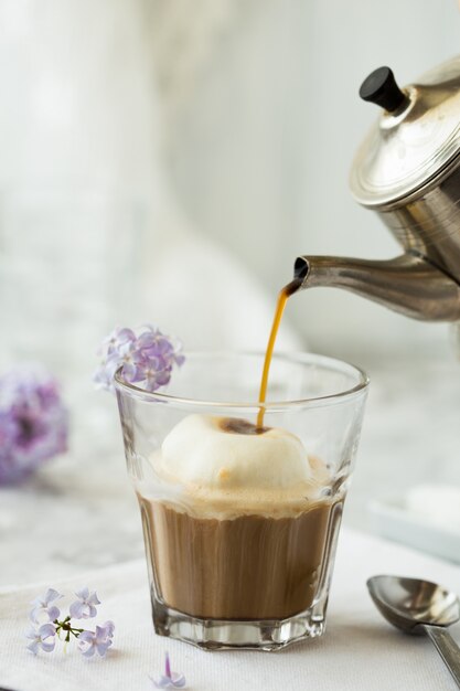 Glace au café en verre. Boisson chaude et savoureuse pleine de caféine avec de la mousse de lait sur le dessus.