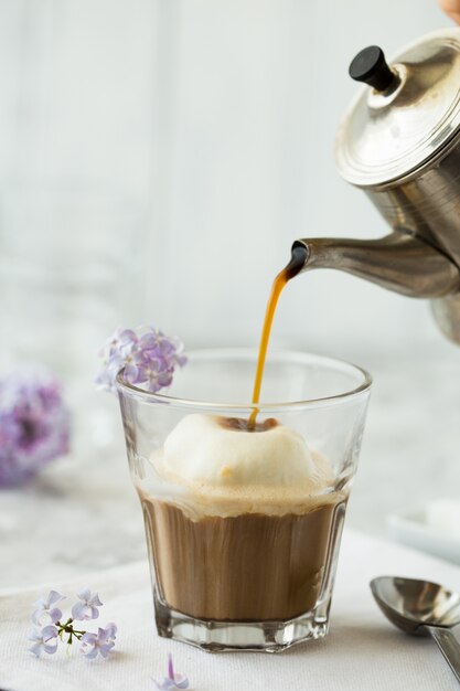 Glace au café en verre. Boisson chaude et savoureuse pleine de caféine avec de la mousse de lait sur le dessus.