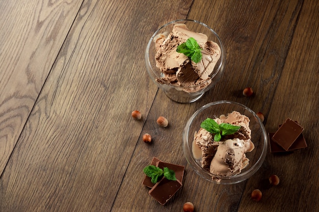 Glace au chocolat faite maison avec des feuilles de menthe, saupoudrée de chocolat dans un bol en verre