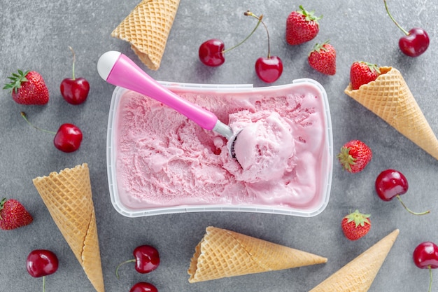 Glace aux baies fruitées maison avec cuillère à glace en boîte.