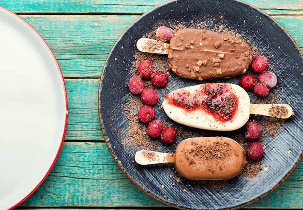 Glace sur bâtonnets au chocolat. Glace enrobée de chocolat avec confiture de cerises