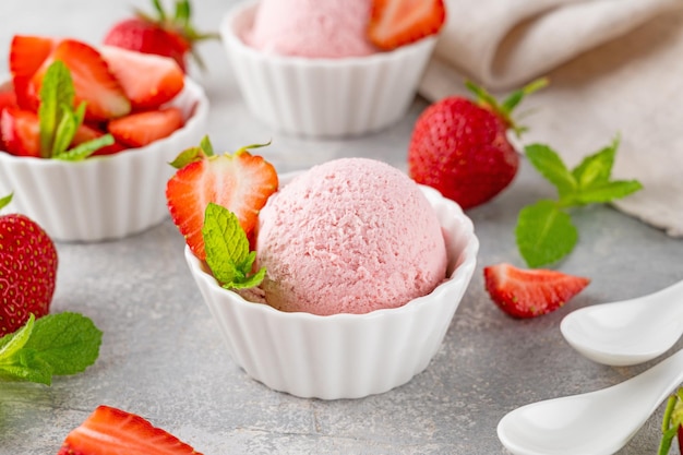 Glace à la fraise avec des baies fraîches dans un bol sur un fond de béton gris Mise au point sélective