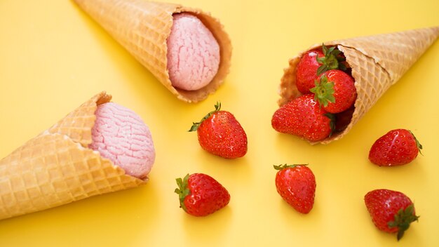 Glace à la fraise dans un cornet gaufré glace et baies sur fond jaune