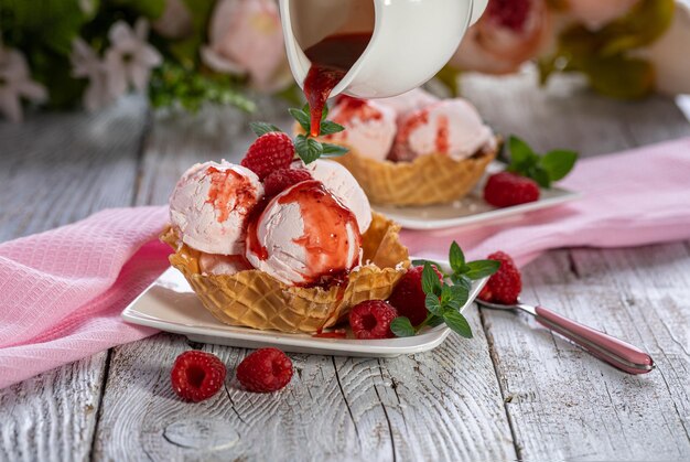 Glace à la framboise dans des bols à gaufres sur fond clair