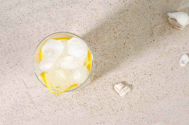 Photo glace froide dans un verre d'eau sur le sable summer drink concept