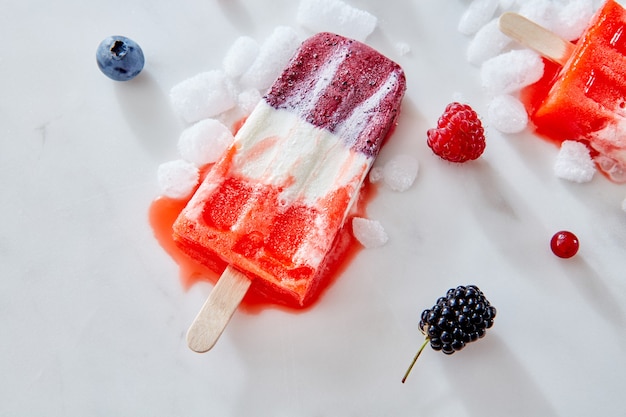 Glace maison sur un bâton avec un morceau de fruits