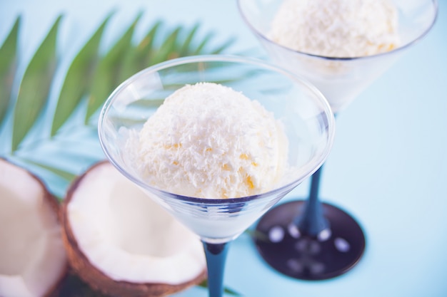 Glace à la noix de coco sur le fond bleu avec feuille de palmier et noix de coco