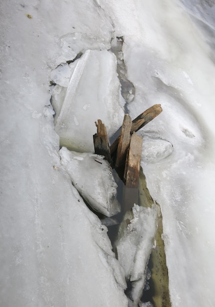 Glace sur la rivière brisée par des planches