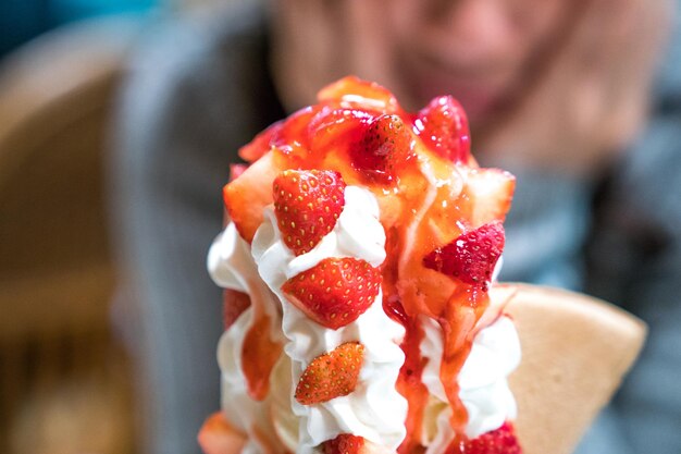 Glace tour sundae aux fraises avec crème fouettée et sauce aux fraises.