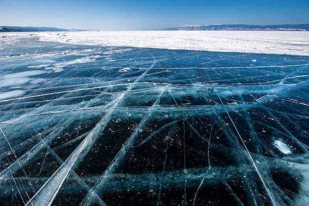 Glace transparente sur le lac Baïkal avec de grandes belles fissures aux beaux jours