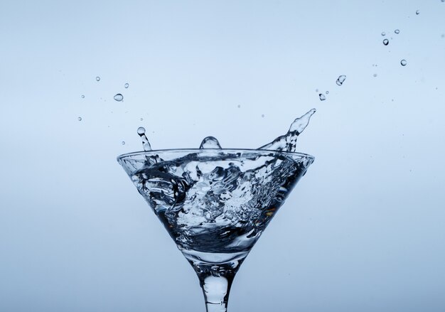 Glace en verre avec éclaboussures d'eau sur la surface bleue