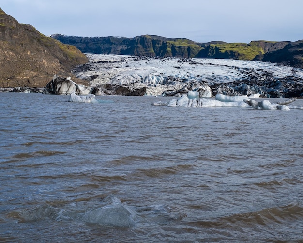 Glacier pittoresque de Solheimajokull dans le sud de l'Islande La langue de ce glacier glisse du volcan Katla Belle lagune de lac glaciaire avec des blocs de glace et des montagnes environnantes