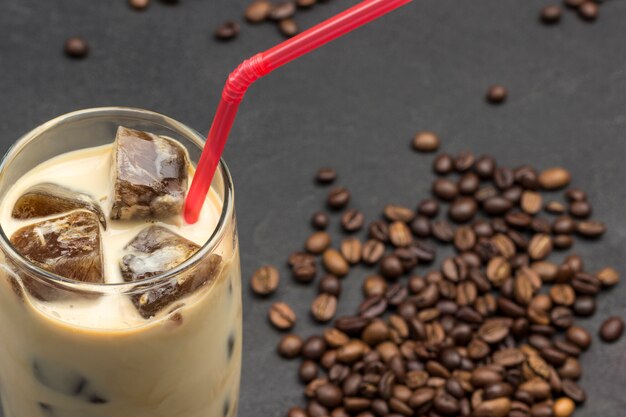 Glaçons de café en verre avec du lait et de la paille rouge.