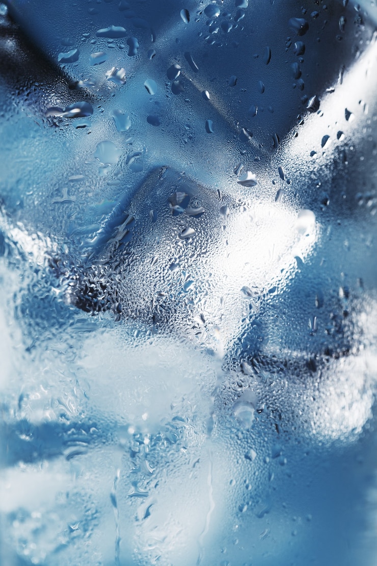 Photo des glaçons dans un verre embué avec des gouttes d'eau glacée macro close-up