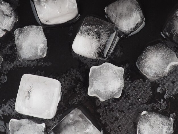 Glaçons sur fond de tableau noir avec des gouttes d'eau.