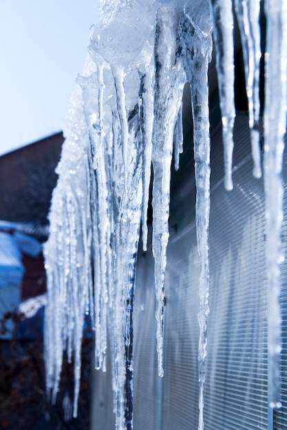 Photo les glaçons fondent. dégel printanier. hiver chaud . les glaçons se bouchent. gros plan d'un grand glaçon ondulé avec plus de glaçons fondants à côté et un fond d'hiver doux.