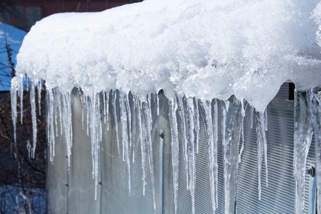 Les glaçons fondent. Dégel printanier. Hiver chaud . Les glaçons se bouchent. Gros plan d'un grand glaçon ondulé avec plus de glaçons fondants à côté et un fond d'hiver doux.