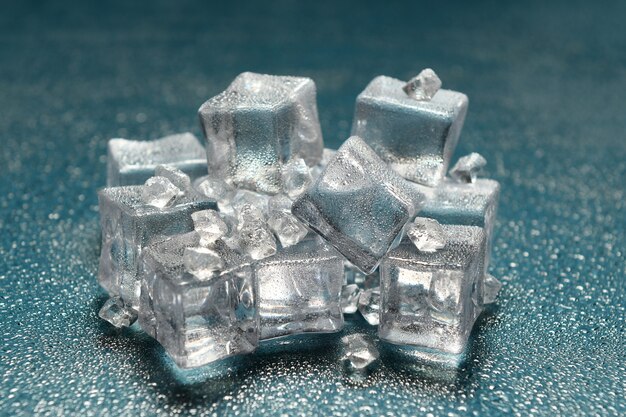 glaçons sur une surface bleue avec des gouttes d'eau