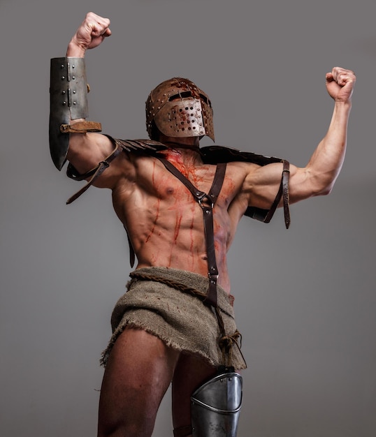 Photo gladiateur sanglant agressif. isolé sur fond gris.