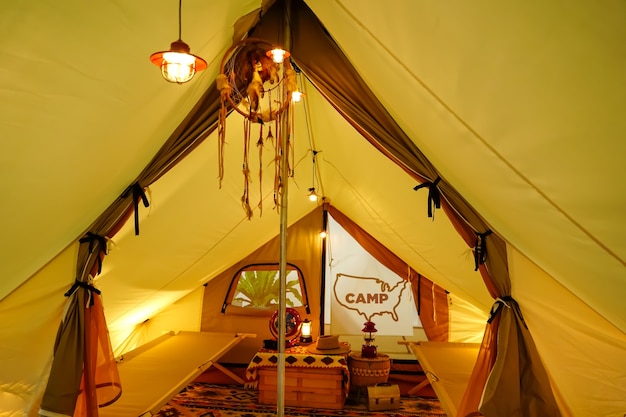 Glamping à l'intérieur de la tente dans une lumière jaune chaude