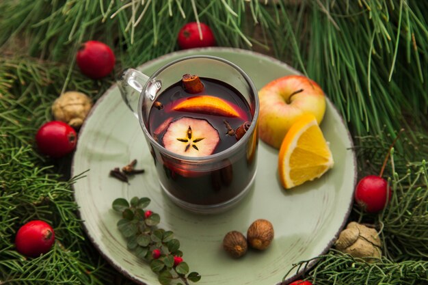 Glintwine dans une tasse de boisson alcoolisée chaude maison pour les vacances avec des branches de sapin comme décorations