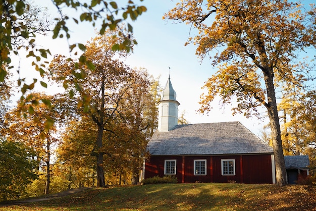 Église en bois soignée dans la forêt d'automne Paysage d'église d'automne Église en plein air