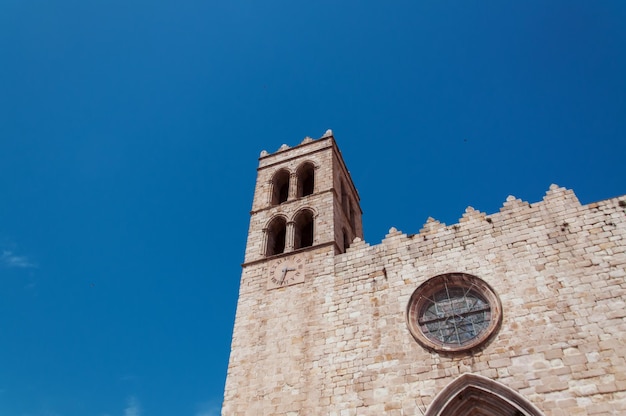 Église médiévale avec une horloge sur un fond de ciel bleu