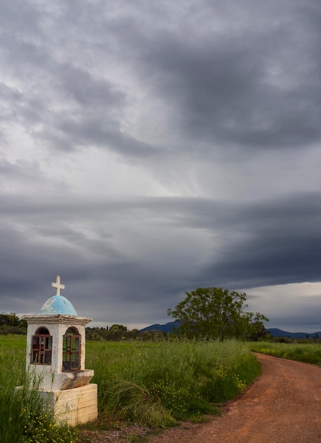 Église miniature traditionnelle de Candelakia par la route avec une bougie allumée et des icônes en Grèce