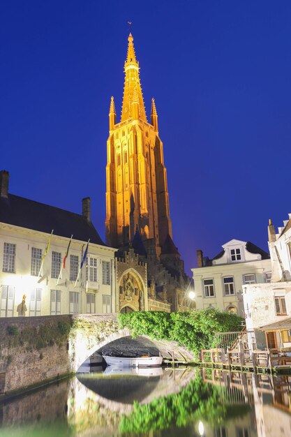 Église Notre-Dame et canal illuminé la nuit Bruges Belgique