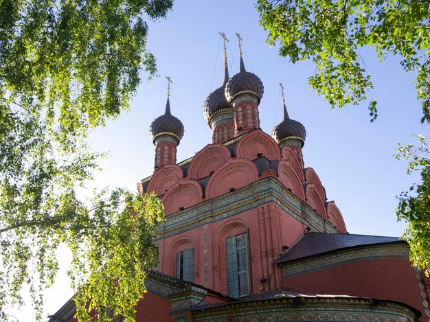 Église russe entourée de feuilles de bouleau vert en été. L'église de l'Épiphanie