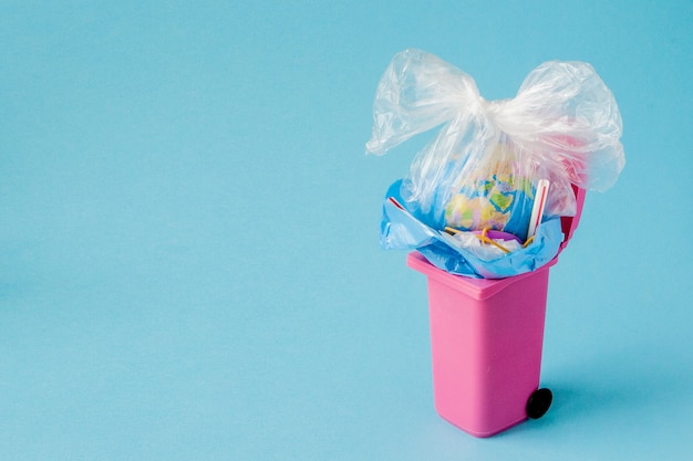 Le globe terrestre se trouve à la poubelle. Le globe se trouve dans un tas de plastique. Pollution plastique de la nature.