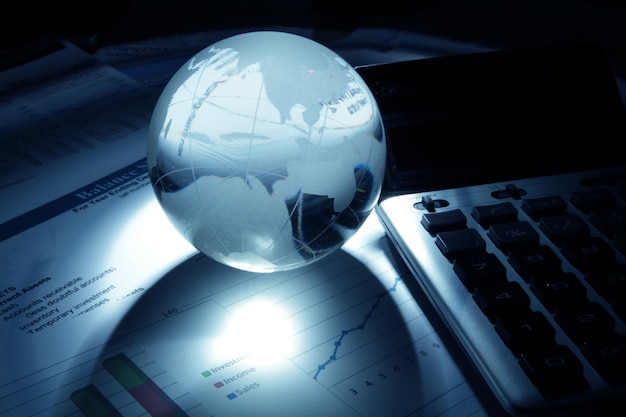 Globe en verre et calculatrice sur les rapports financiers Close-up