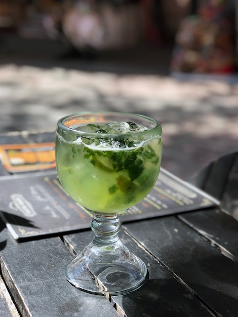 Un globe en verre de mojito sur une table en bois dans un bar