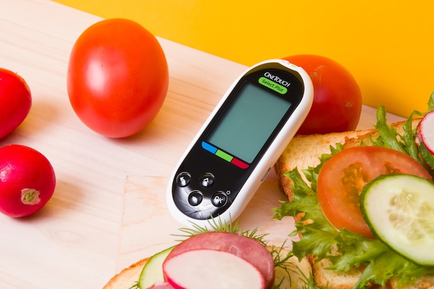 Glucomètre et sandwichs sains sur une table en bois