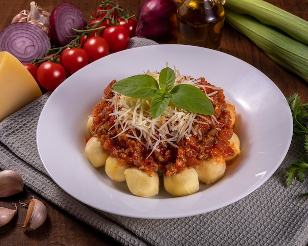 Gnocchi bolognais à la sauce tomate bio naturelle, sans pesticides, avec du parmesan râpé et des feuilles de basilic