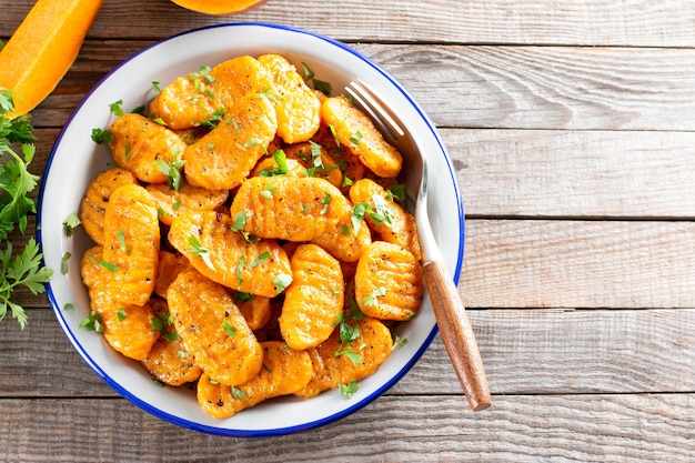 Gnocchi avec une citrouille sur la plaque. Boulettes italiennes au beurre. Repas d'automne. Vue de dessus, espace de copie