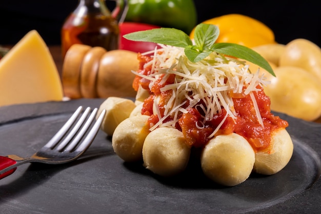 Gnocchi à la sauce tomate bio naturelle sans pesticides avec du parmesan râpé et des feuilles de basilic.