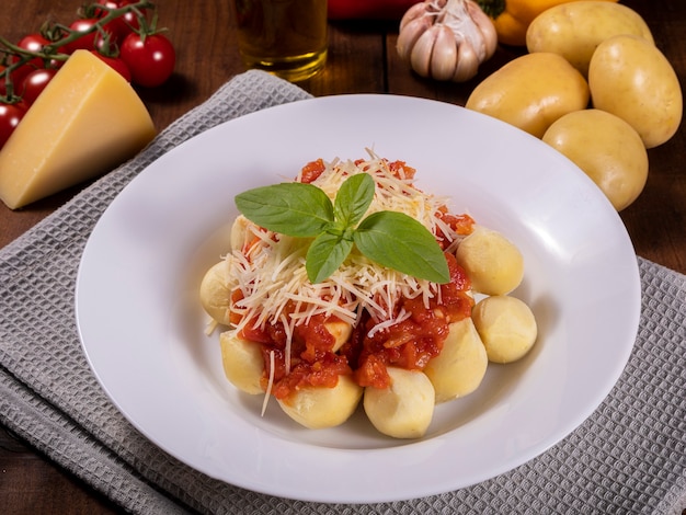 Gnocchi à la sauce tomate bio naturelle sans pesticides avec du parmesan râpé et des feuilles de basilic.