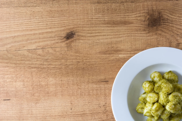 Gnocchis au pesto en plaque sur une table en bois