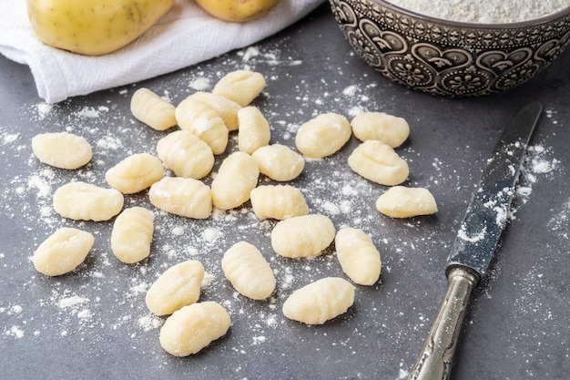 Gnocchis de pâtes italiennes non cuites sur fond de pierre avec espace de copie
