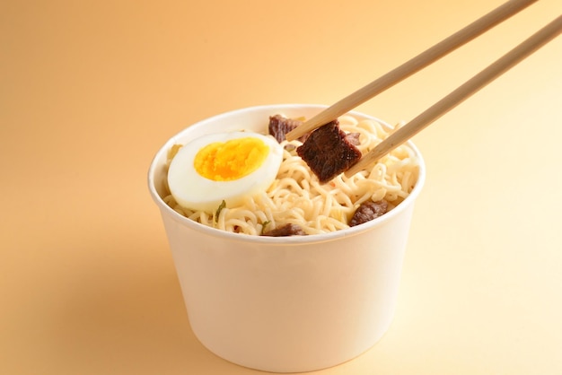 Gobelet en papier avec nouilles ramen instantanées au bœuf et légumes.