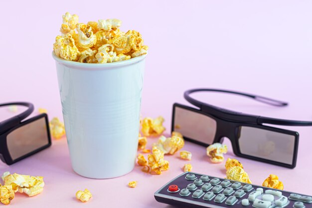 Photo gobelet en papier avec pop-corn, lunettes 3d et télécommande tv