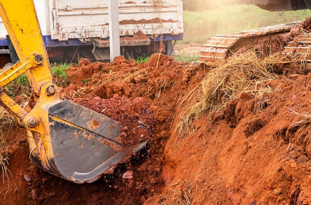 Godet d'excavatrice creusant le sol pour le chargement sur camion