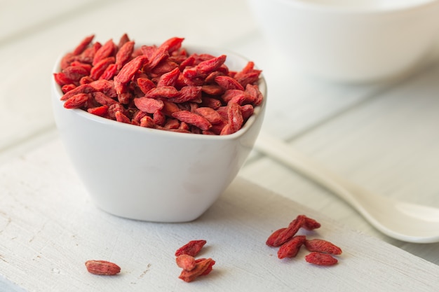 Photo goji dans un bol sur la table en bois.