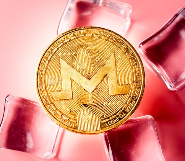 Golden Monero XRM sur fond rose clair Gros plan macro shot Cryptocurrency
