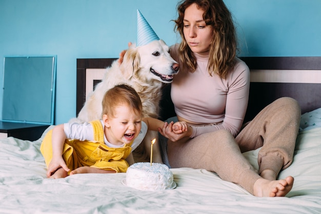 Golden retriever du Labrador avec un petit enfant fête son anniversaire avec un gâteau