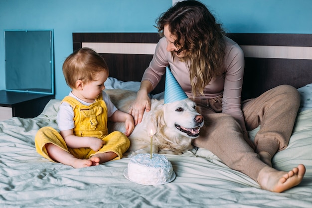 Golden retriever du Labrador avec un petit enfant fête son anniversaire avec un gâteau