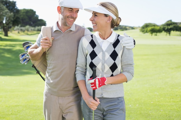 Golf couple souriant les uns aux autres sur le green